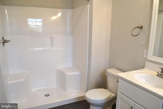 a white toilet sitting next to a bath tub