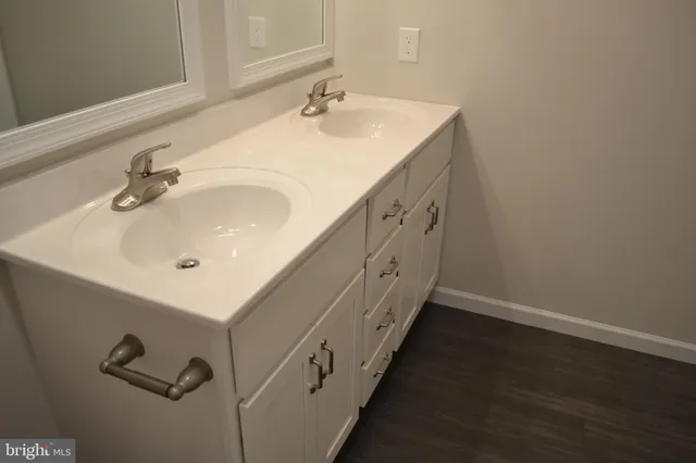 a bathroom with double vanity sink and mirror