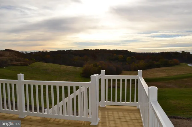 a view of a balcony with wooden floor and fence