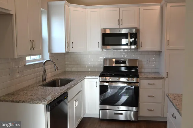 a kitchen with granite countertop a stove and a sink