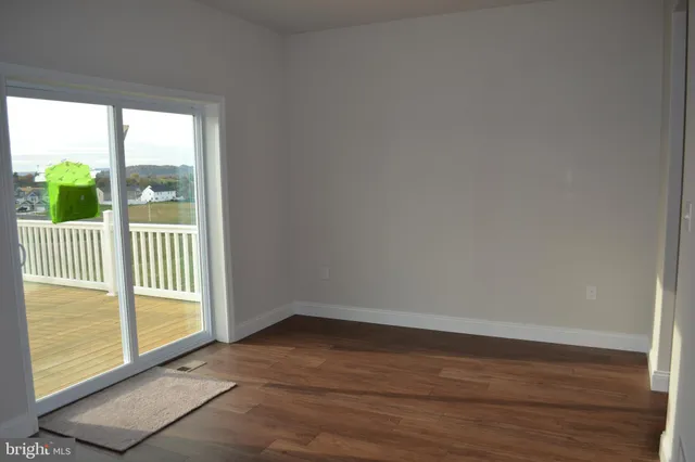 a view of a room that has wooden floor and a window