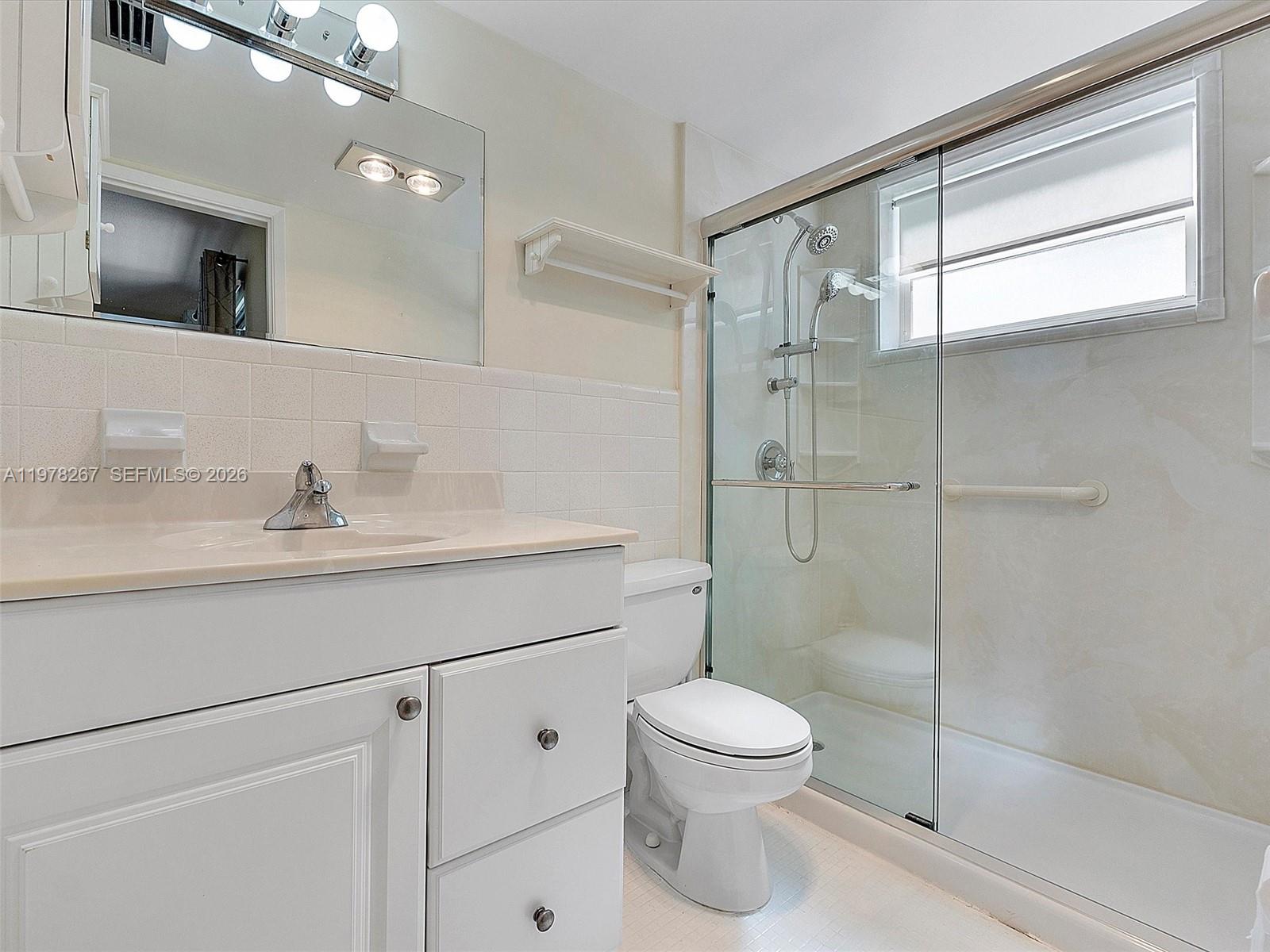 2050 Northeast 39th Street, Unit W212 Lighthouse Point, FL 33064 - Photo 6 of 17 a bathroom with a sink a toilet and shower