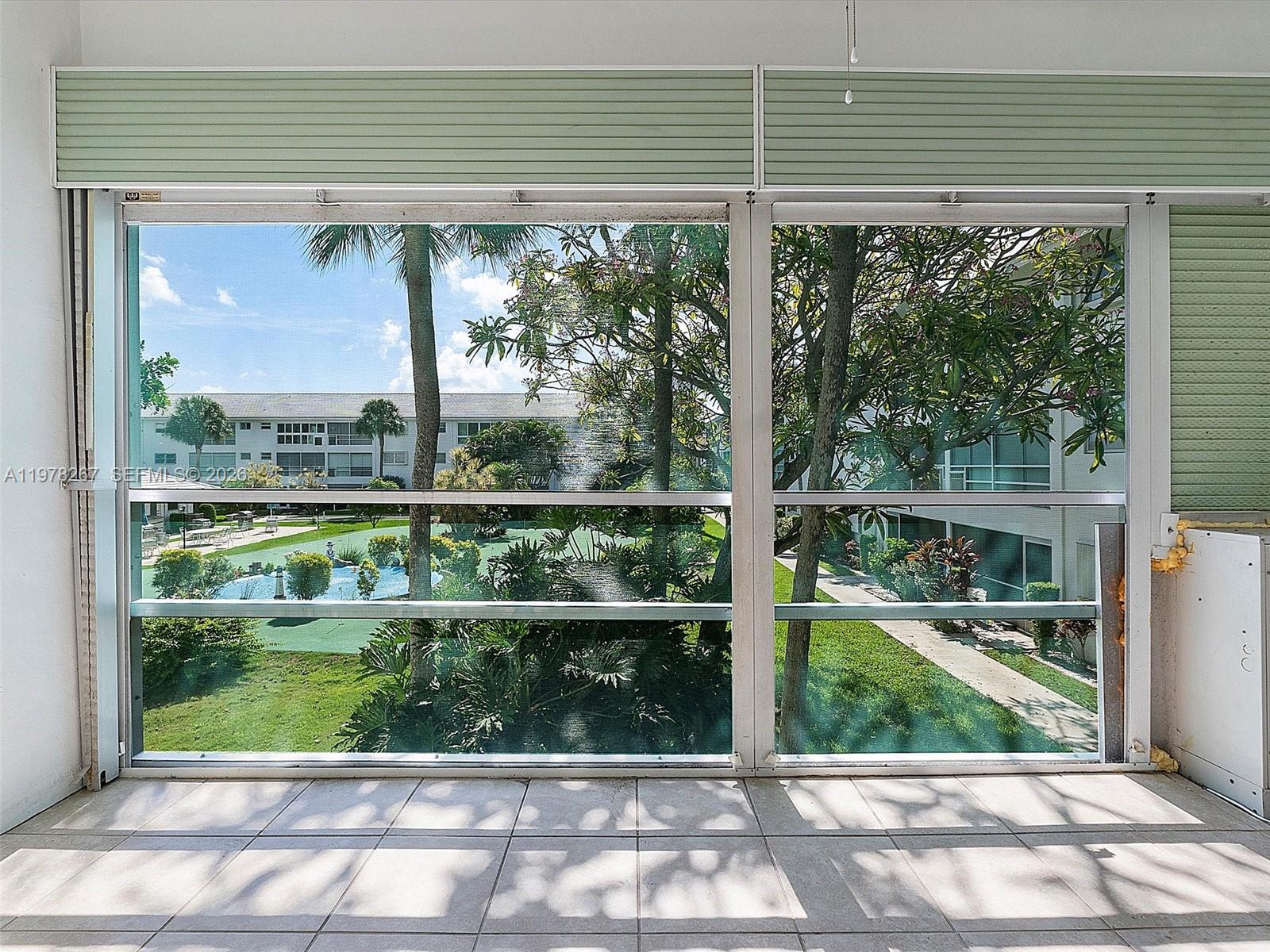 2050 Northeast 39th Street, Unit W212 Lighthouse Point, FL 33064 - Photo 7 of 17 a view of a green room with wooden floor and a stairs