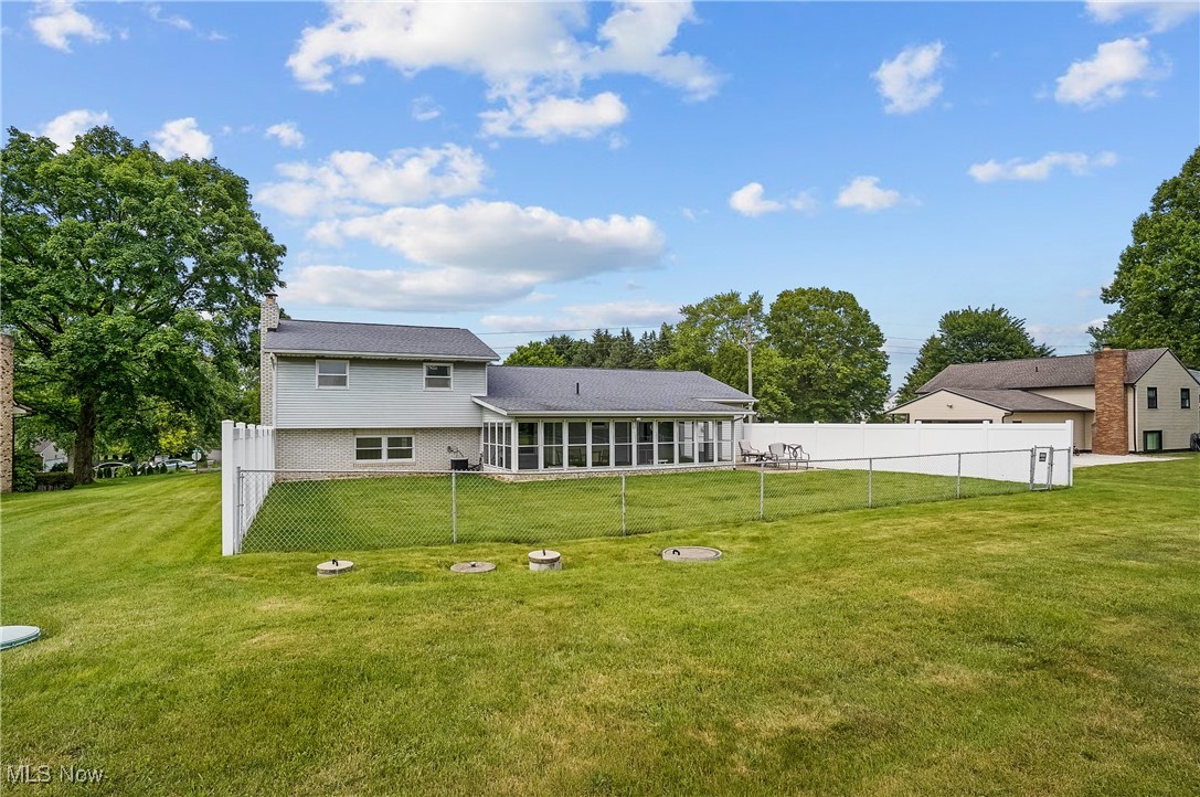3262 Wright Road Northwest Uniontown, OH 44685 - Photo 5 of 37 Rear view of property with a sunroom, a chimney, and brick siding