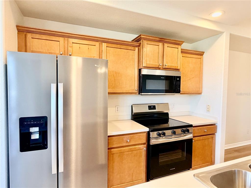 819 Fairwaycove Lane, Unit 102 Bradenton, FL 34212 - Photo 14 of 56 a kitchen with stainless steel appliances a stove a microwave and a refrigerator