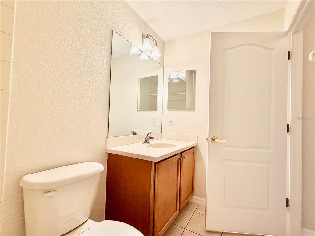 819 Fairwaycove Lane, Unit 102 Bradenton, FL 34212 - Photo 35 of 56 a bathroom with a toilet a sink and mirror