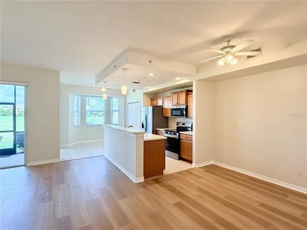 a view of a large kitchen with wooden floor and a window