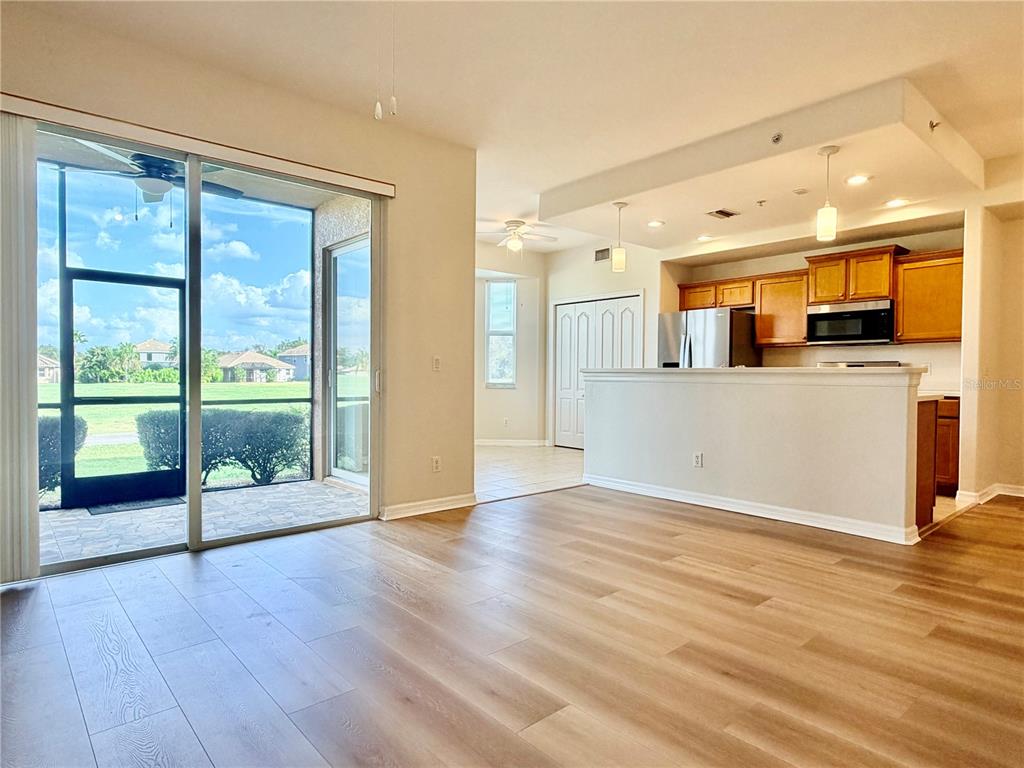 819 Fairwaycove Lane, Unit 102 Bradenton, FL 34212 - Photo 5 of 56 a view of a large kitchen with wooden floor and a window