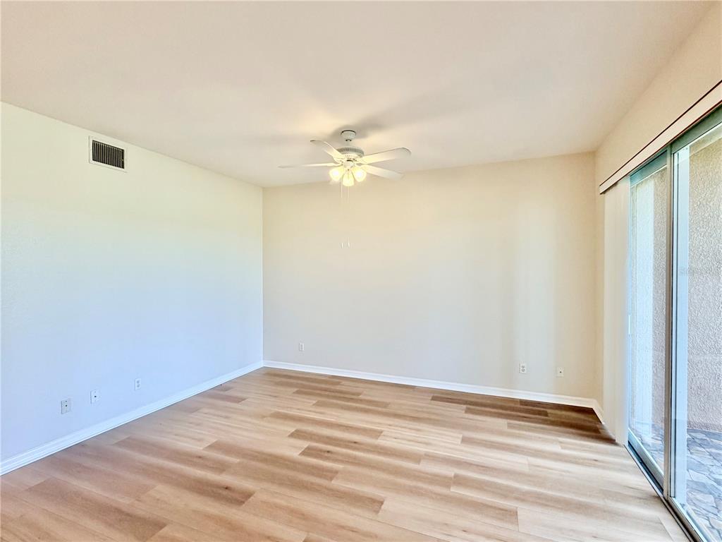 819 Fairwaycove Lane, Unit 102 Bradenton, FL 34212 - Photo 10 of 56 a view of a room with wooden floor and a ceiling fan