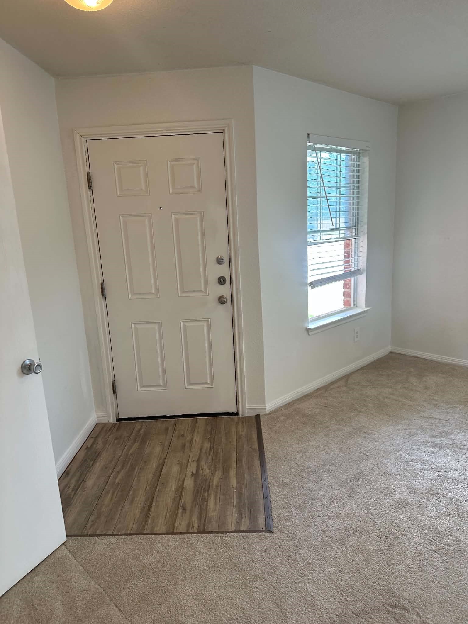 18312 Crestwind Lane Elgin, TX 78621 - Photo 2 of 15 A well-lit entry welcomes guests with durable plank flooring transitioning to soft carpeting.