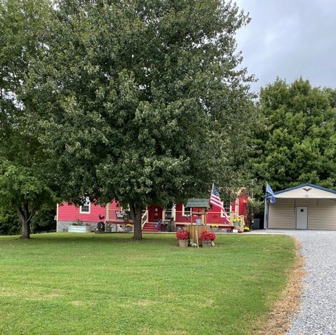 a front view of a house with a yard and trees