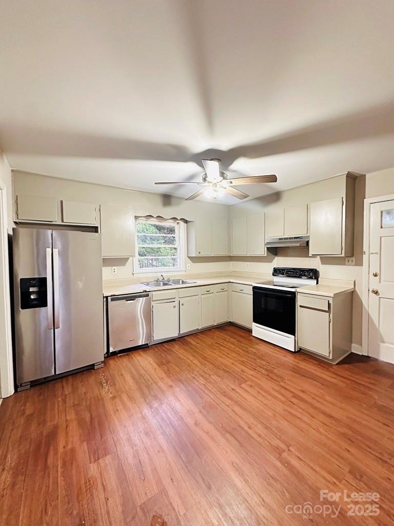 a large kitchen with white cabinets and stainless steel appliances