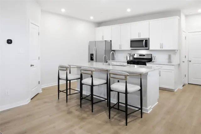 a kitchen with stainless steel appliances a stove a sink refrigerator and microwave