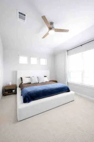 a bedroom with a bed and a large window