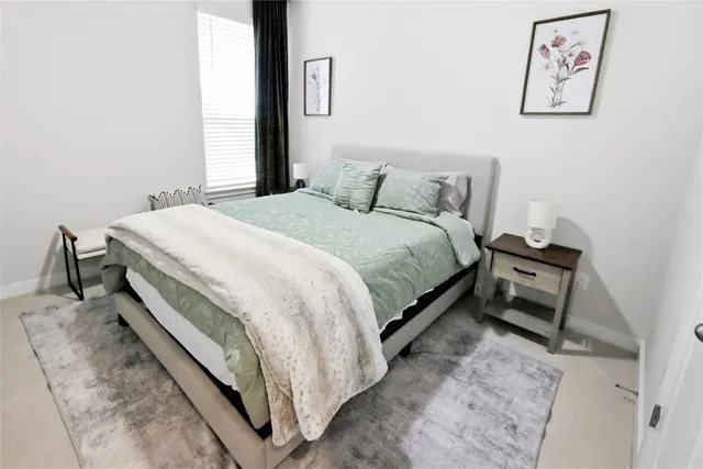 a large bed sitting in a bedroom next to a window