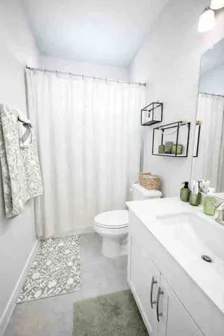 a bathroom with a sink a toilet and shower curtain