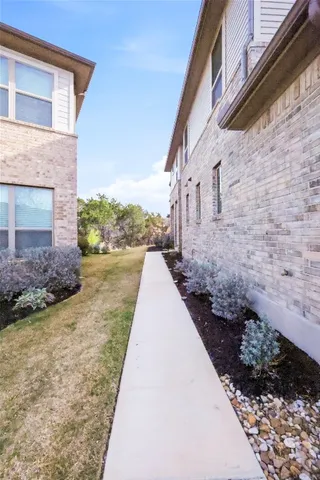 a view of a pathway of house with flower pots