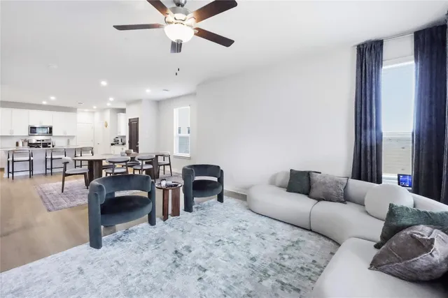 a living room with furniture kitchen view and a chandelier
