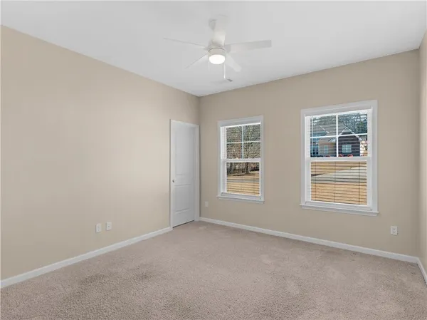 an empty room with a window and a ceiling fan