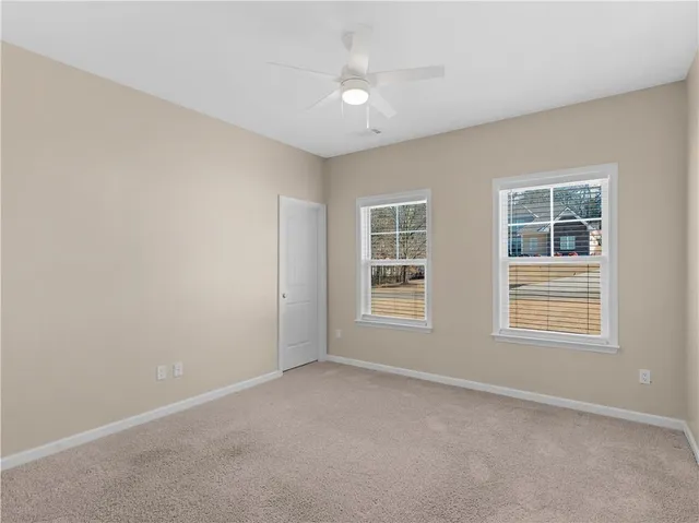 an empty room with a window and a ceiling fan
