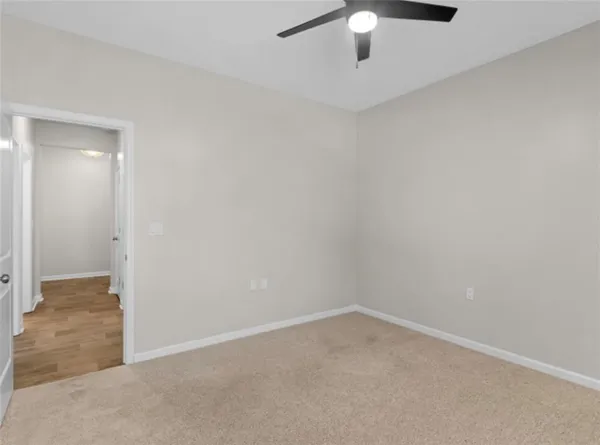 an empty room with a ceiling fan and a window