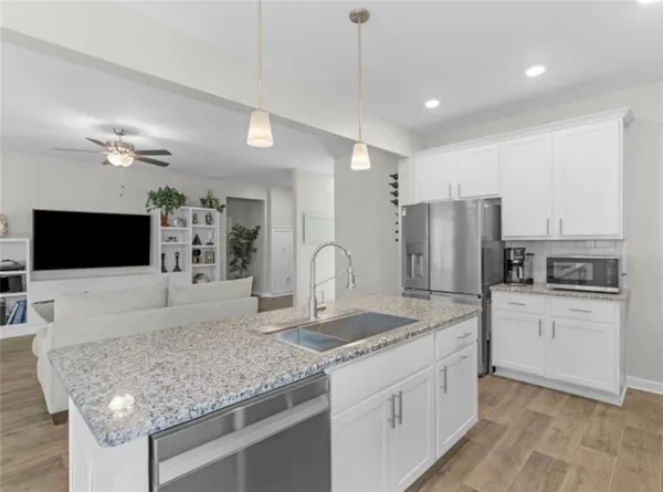 a kitchen with stainless steel appliances granite countertop a sink refrigerator and microwave