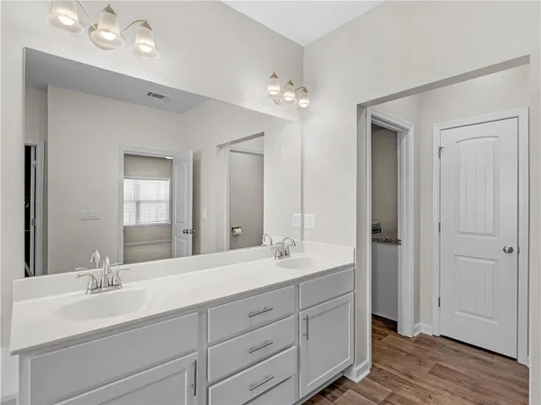 a bathroom with double vanity sinks and a mirror