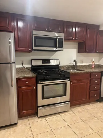 a kitchen with granite countertop wooden cabinets and a stove top oven
