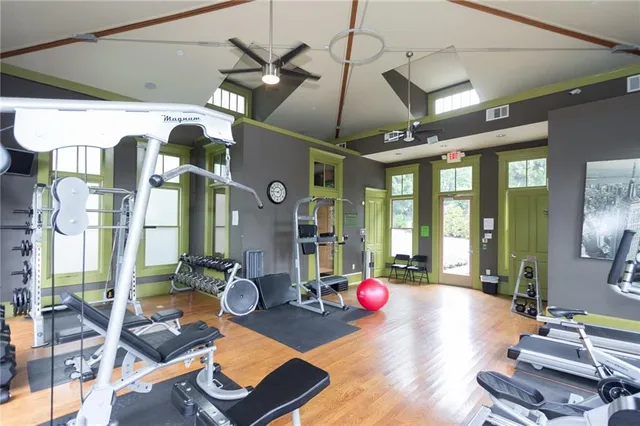 a room with lots of gym equipment and large windows