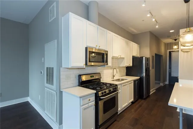 a kitchen with stainless steel appliances granite countertop a stove a refrigerator and a microwave