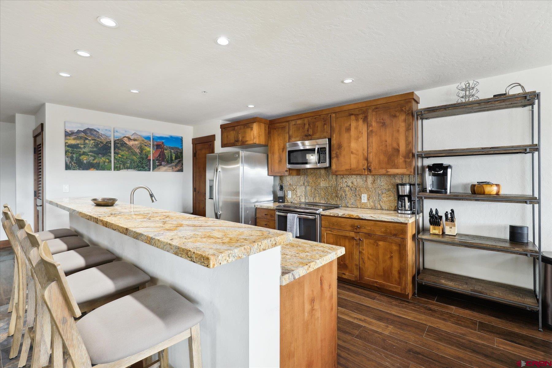 24 Sheol Street, Unit R505 Durango, CO 81301 - Photo 8 of 36 a kitchen with stainless steel appliances kitchen island granite countertop a sink stove and refrigerator