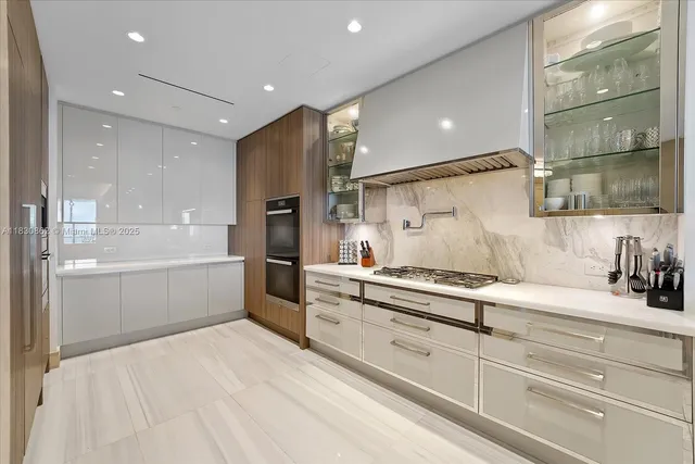 a large white kitchen with stainless steel appliances and cabinets