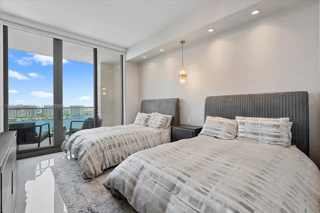 a bedroom with two large bed and a large window