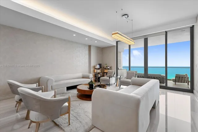 a living room with furniture a ceiling fan and a large window