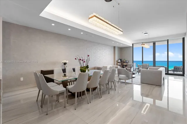 a view of a dining room with furniture a chandelier and wooden floor
