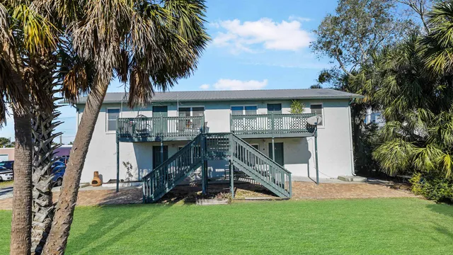 a view of a backyard with a slide and a large tree