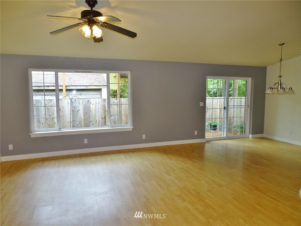 301 Harbor View Loop Southeast Ocean Shores, WA 98569 - Photo 14 of 29 an empty room with chandelier fan and windows