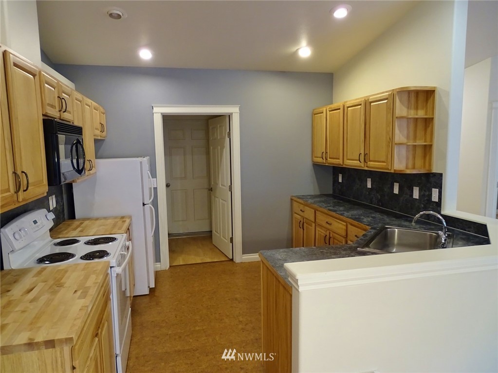 301 Harbor View Loop Southeast Ocean Shores, WA 98569 - Photo 17 of 29 a kitchen with a sink a stove and a refrigerator