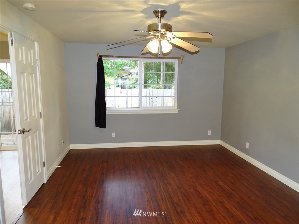 301 Harbor View Loop Southeast Ocean Shores, WA 98569 - Photo 22 of 29 a view of an empty room with wooden floor and a window