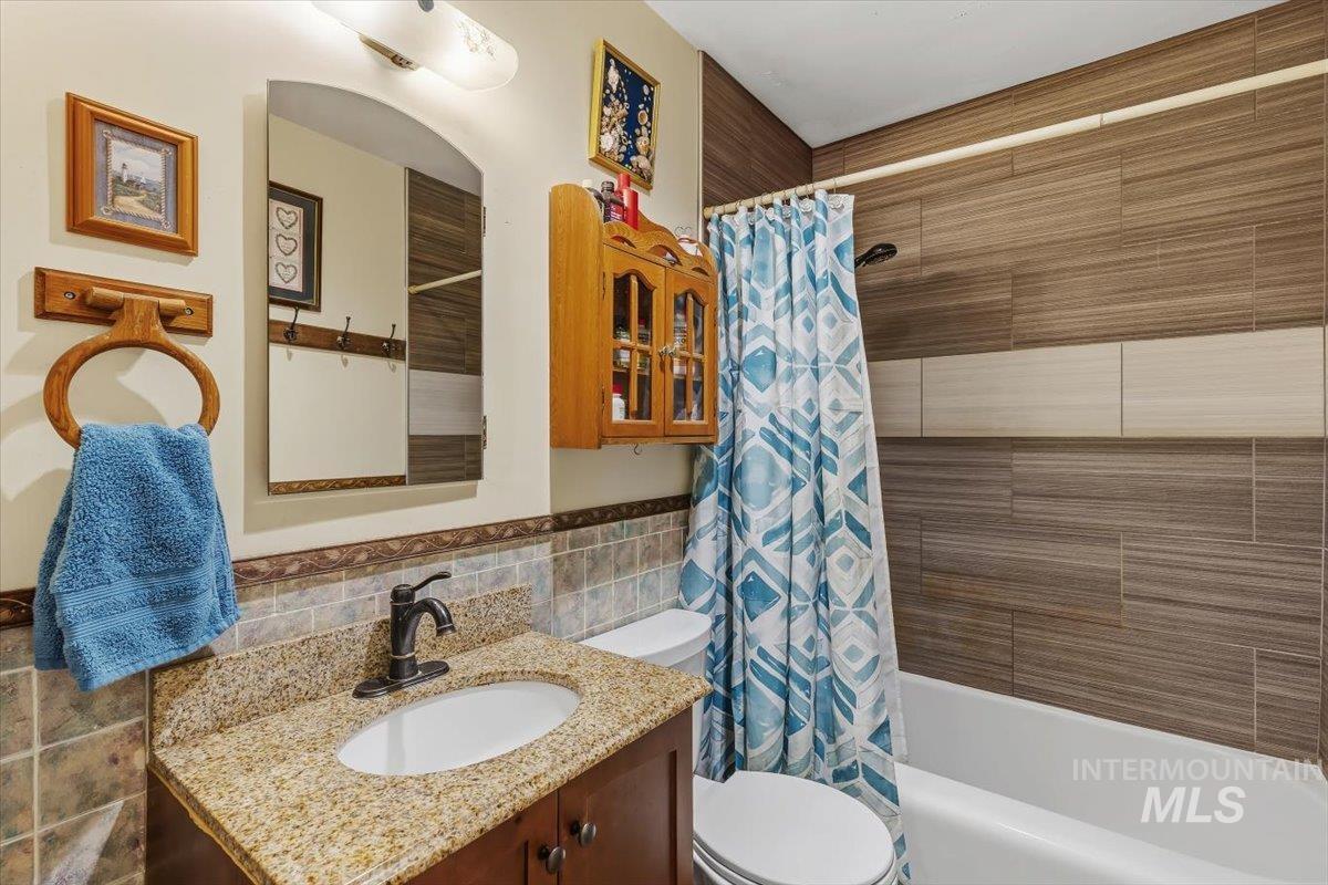 4619 Freemont Street Boise, ID 83706 - Photo 9 of 27 Bathroom featuring a wood-finish vanity with an oval basin and a speckled countertop