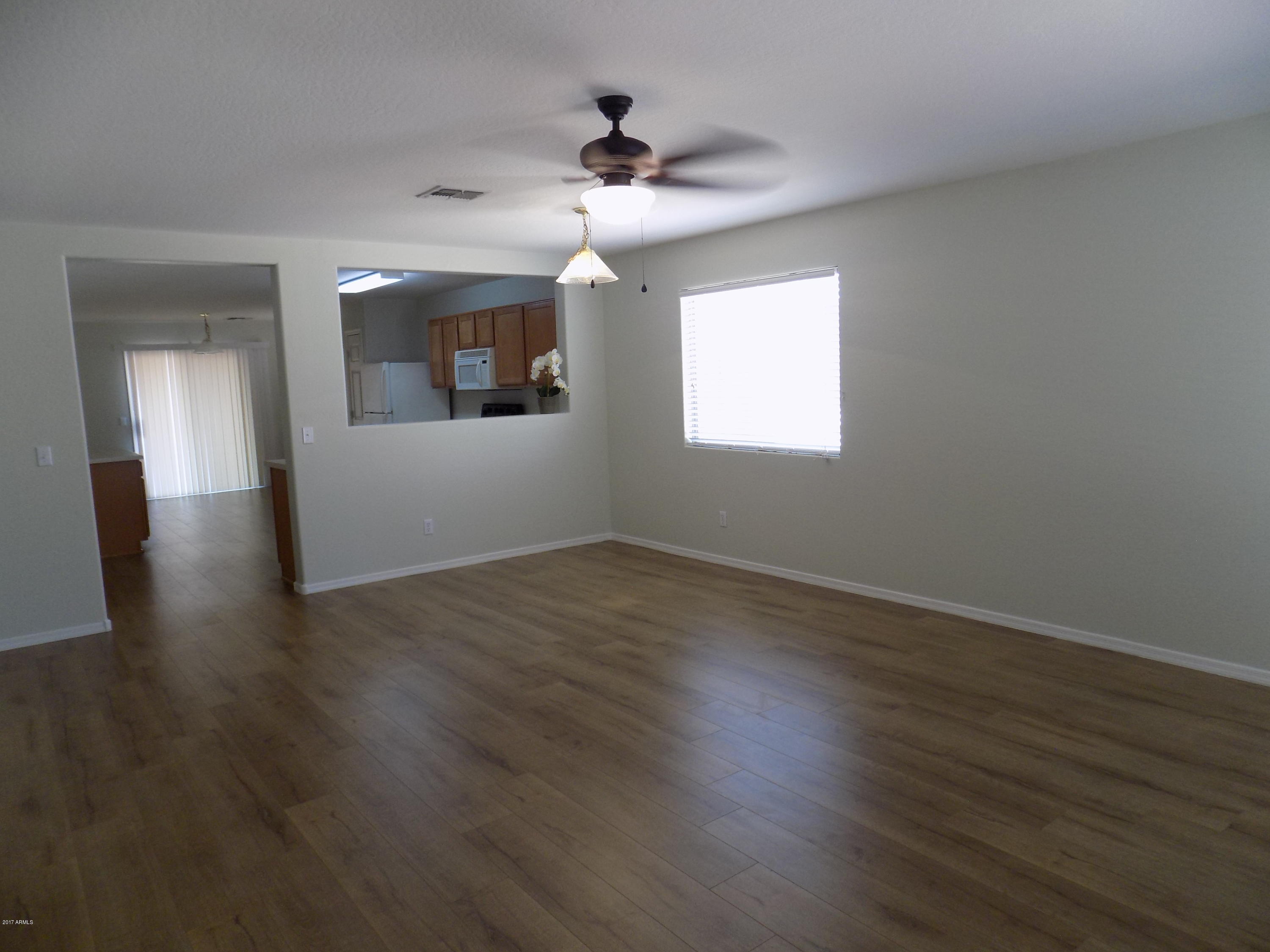 16235 West Redfield Road Surprise, AZ 85379 - Photo 2 of 21 an empty room with wooden floor and windows
