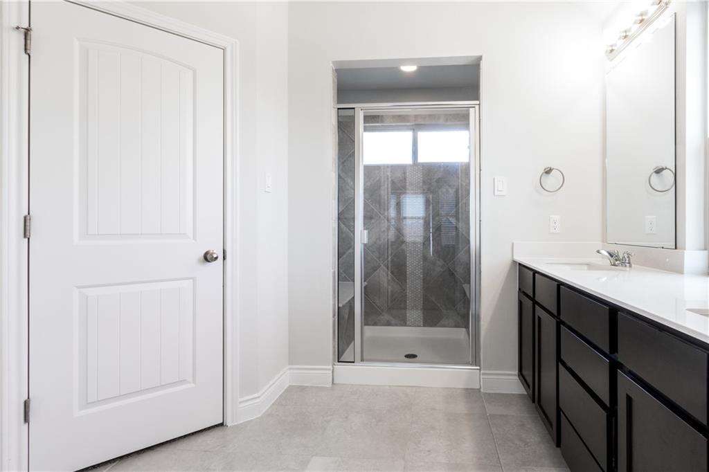 2104 Pindos Pony Way Georgetown, TX 78626 - Photo 17 of 30 A well-appointed bathroom features a spacious vanity and a walk-in shower with tiled surrounds.