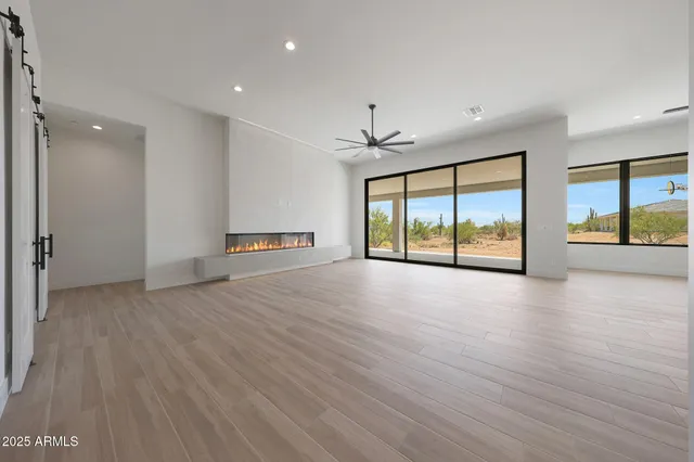 a large kitchen with stainless steel appliances kitchen island a large counter top a sink cabinets and a wooden floor