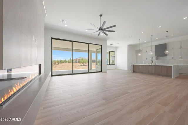 a large kitchen with stainless steel appliances granite countertop a large center island attached withe living room