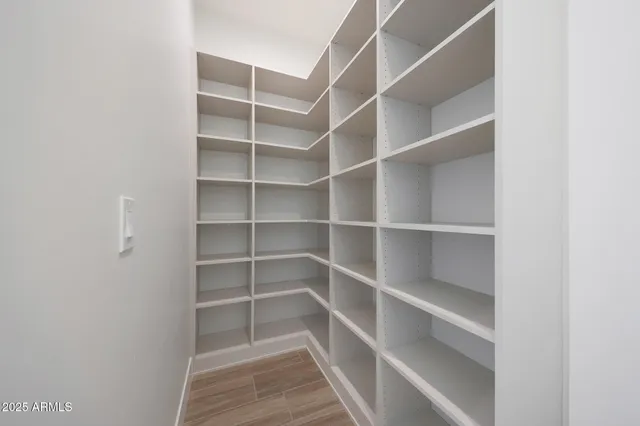 a view of empty room with wooden floor and ceiling fan