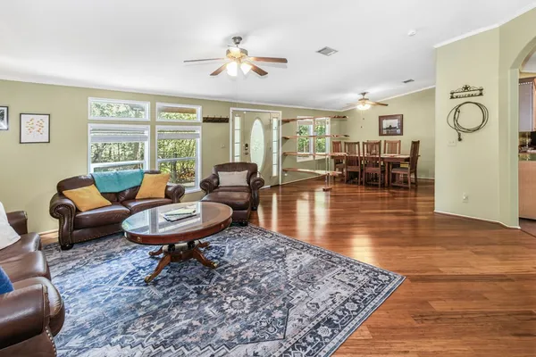 a living room with furniture a chandelier and a dining table