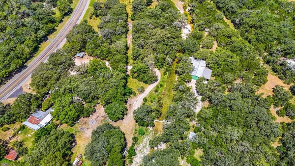 an aerial view of residential house with outdoor space and trees all around