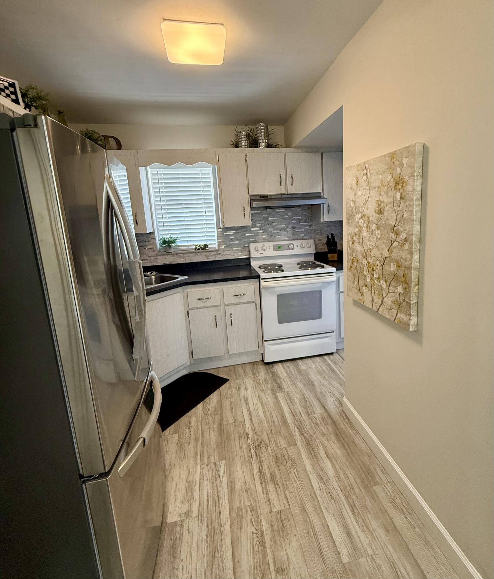 1982 Southwest Palm City Road, Unit F Stuart, FL 34994 - Photo 12 of 34 a kitchen with stainless steel appliances a refrigerator sink and microwave