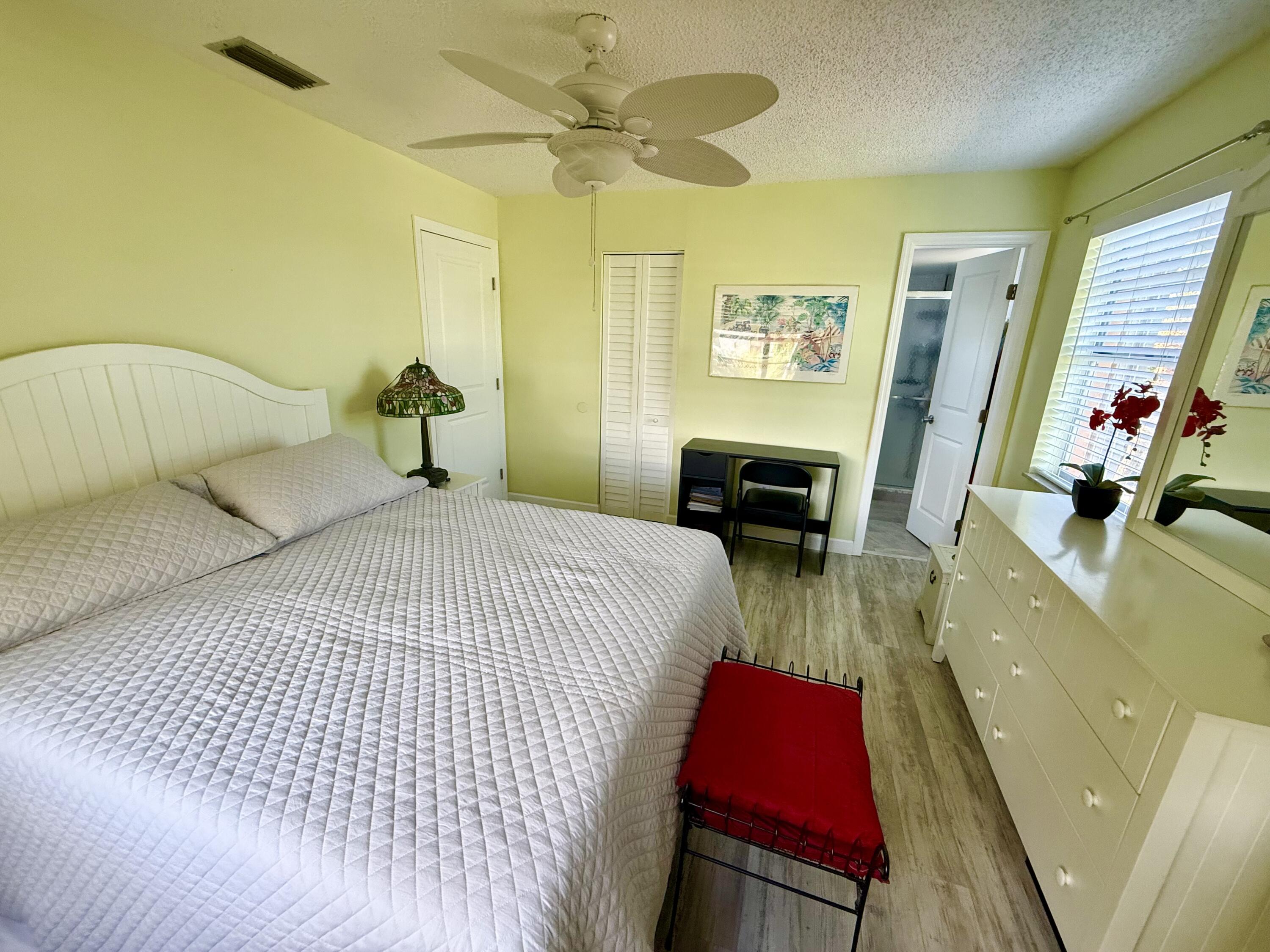 1982 Southwest Palm City Road, Unit F Stuart, FL 34994 - Photo 14 of 34 a bedroom with a bed and a chandelier