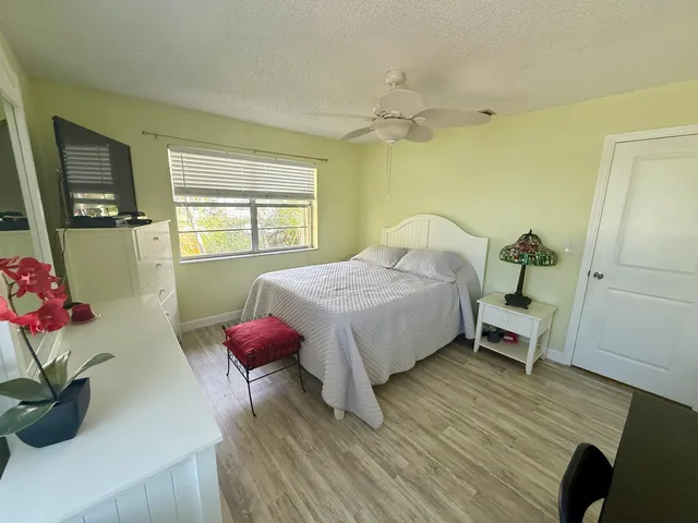 a bedroom with a bed and a potted plant